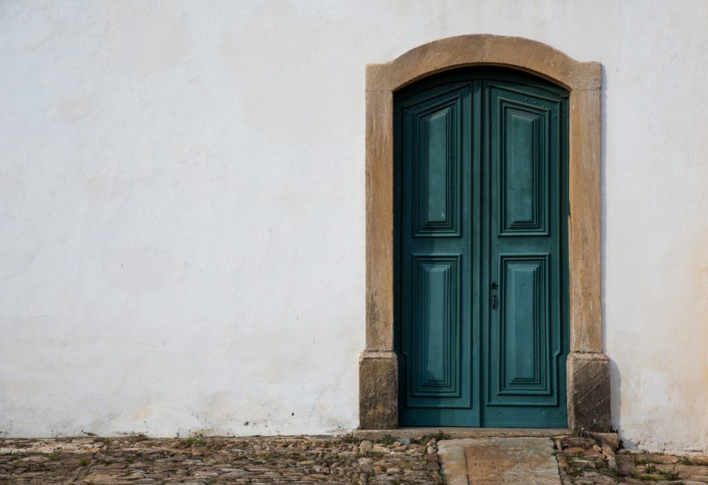 blue wooden door on white concrete wall