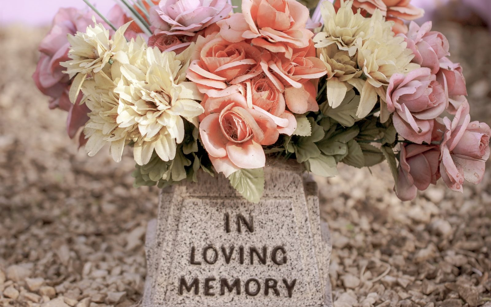 pink and white flowers on gray concrete tomb