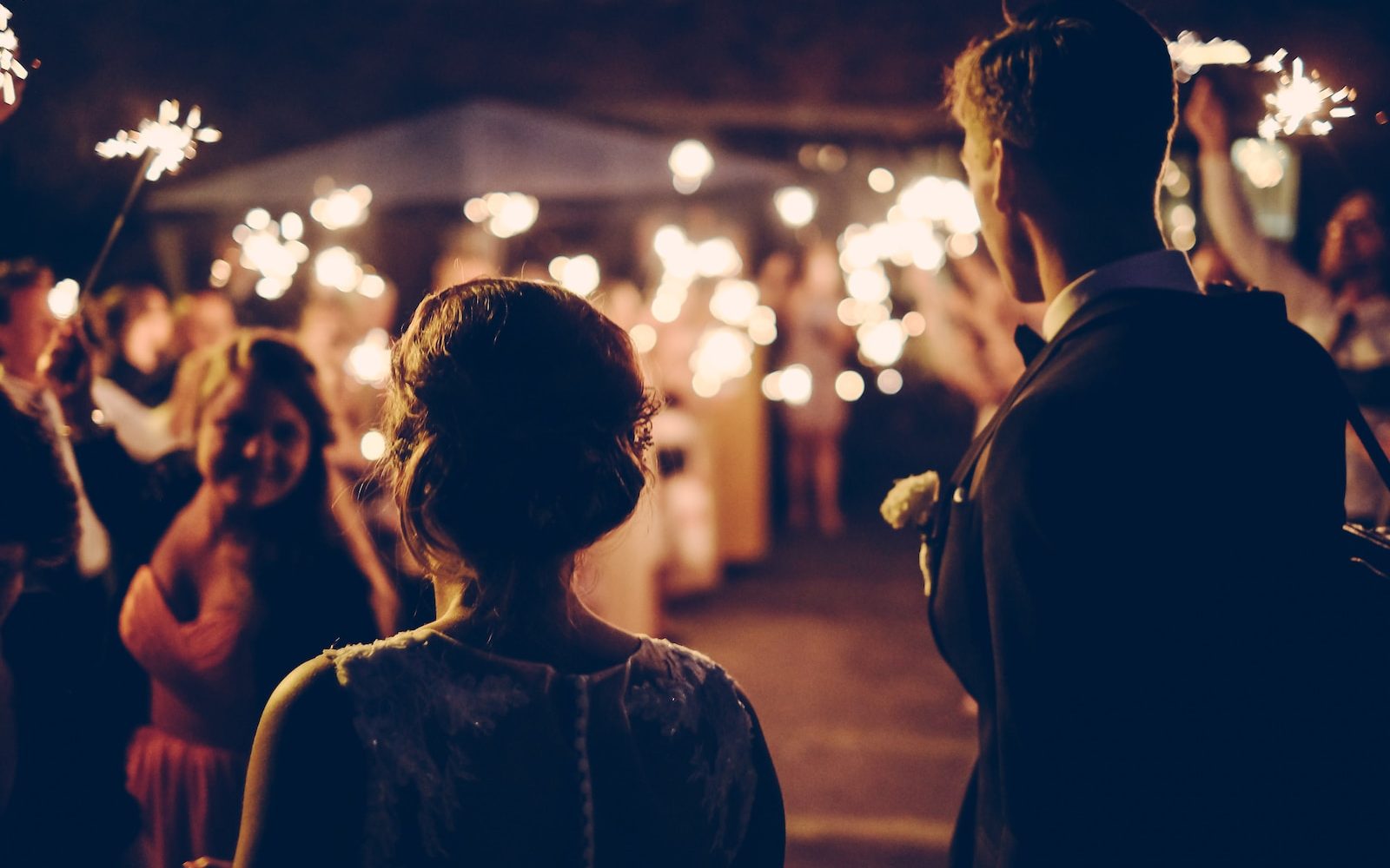 man standing near the woman walking in party during nighttime