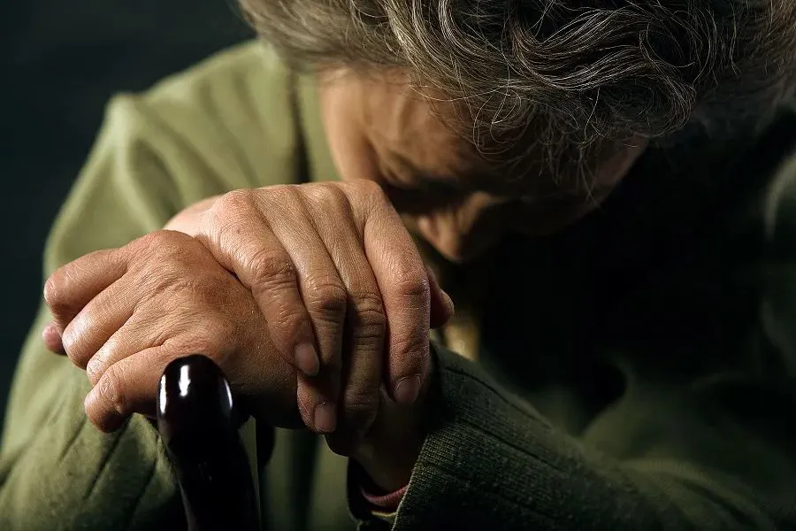 old woman bowing her head